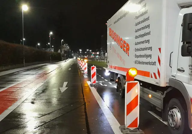 Nächtliche Fahrbahnabsicherung mit Leitbaken und Fahrzeug von Auto-Bissinger